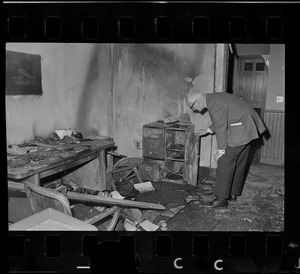 A man inspecting damage caused by a fire in an office