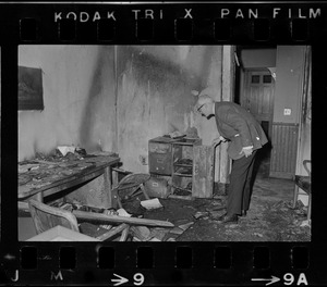 A man inspecting damage caused by a fire in an office