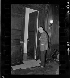 A man standing in front of door, possibly to an office where a fire has occurred