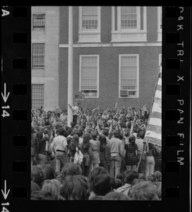 Student protesters gathered around State House flagpole as man lowers flag to half-mast per crowds demands