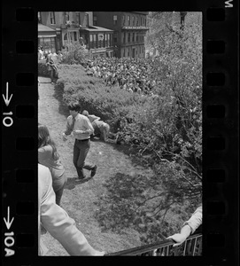 Boston area college students climbing through State House bushes to gather and protest US march into Cambodia and the killing of four Ohio students at Kent State