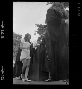 A Tufts University graduate receives her diploma without cap and gown as means of protesting school's administration
