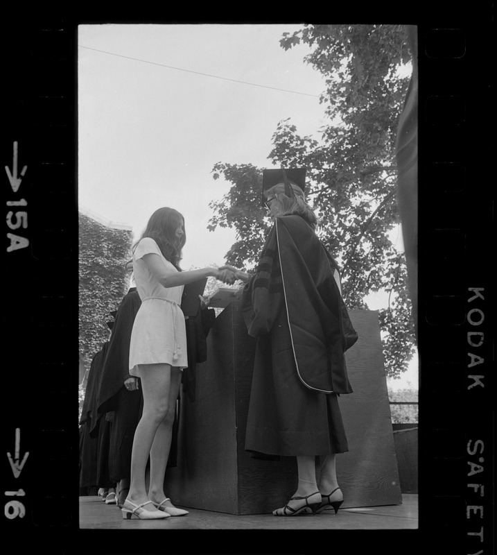 A Tufts University graduate receives her diploma without cap and gown as means of protesting school's administration