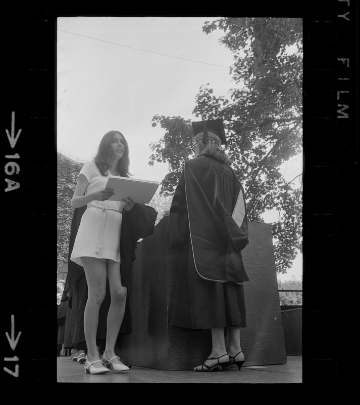 A Tufts University graduate receives her diploma without cap and gown as means of protesting school's administration