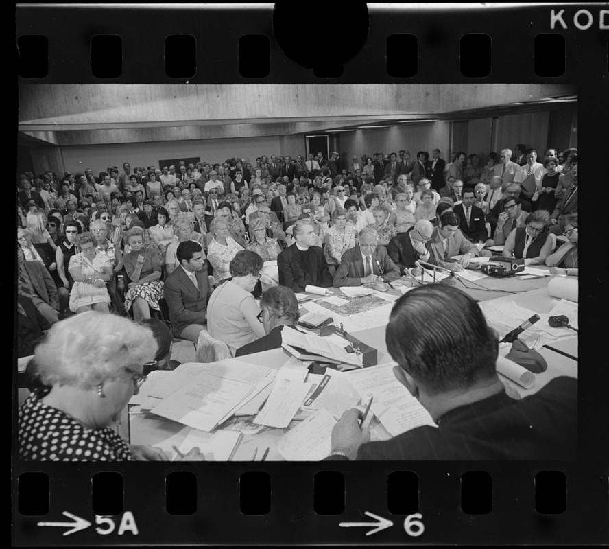 Lewis Weinstein, attorney for Boston College, addresses City Hall hearing with BC President Rev. W. Seavey Joyce at his side