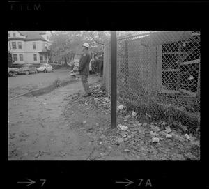 Policeman standing outside fence at Tufts University dormitory construction site, center of student opposition