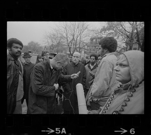 Rev. Robert Drinan, Dean of Boston College Law School and committee chairman of Massachusetts Advisory Committee to the US Civil Rights Commission, surrounded by reporters during student protest at Tufts University