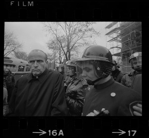 Rev. Robert Drinan, Dean of Boston College Law School and committee chairman of Massachusetts Advisory Committee to the US Civil Rights Commission, standing near police at the Tufts University dormitory construction site that is the center of student opposition