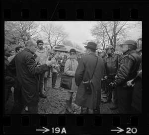 Rev. Robert Drinan standing in front of police at the Tufts University dormitory construction site and speaking with reporters