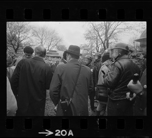 Rev. Robert Drinan, far left and seen from behind, standing with police and others at the Tufts University dormitory construction site