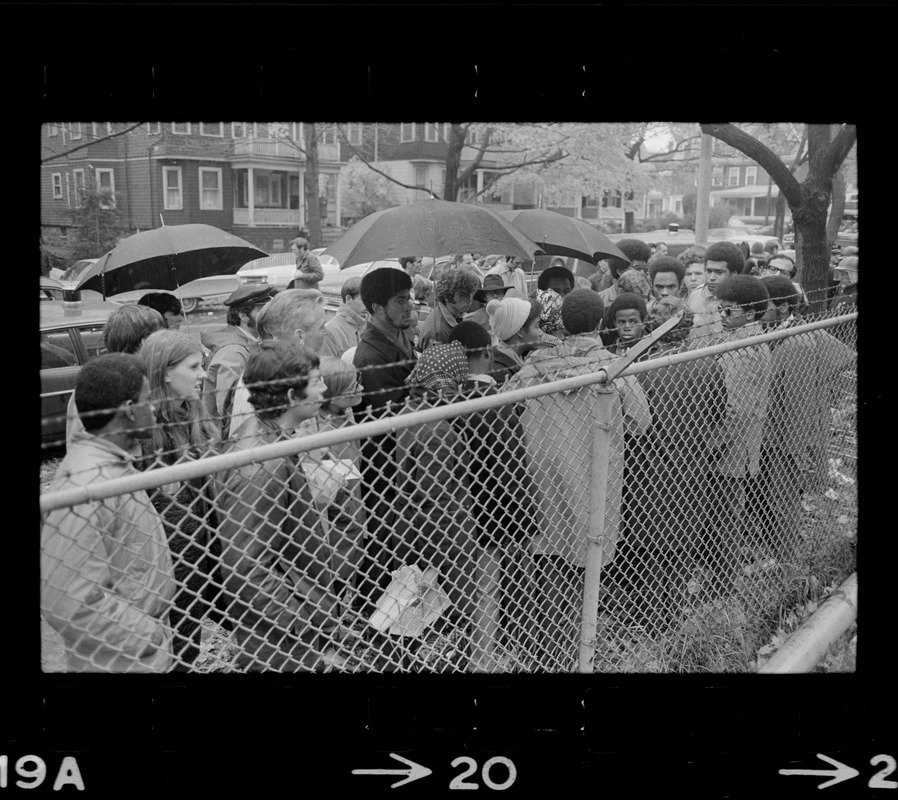 Protesters standing by a fence bordering the Tufts University dormitory construction site, center of student opposition