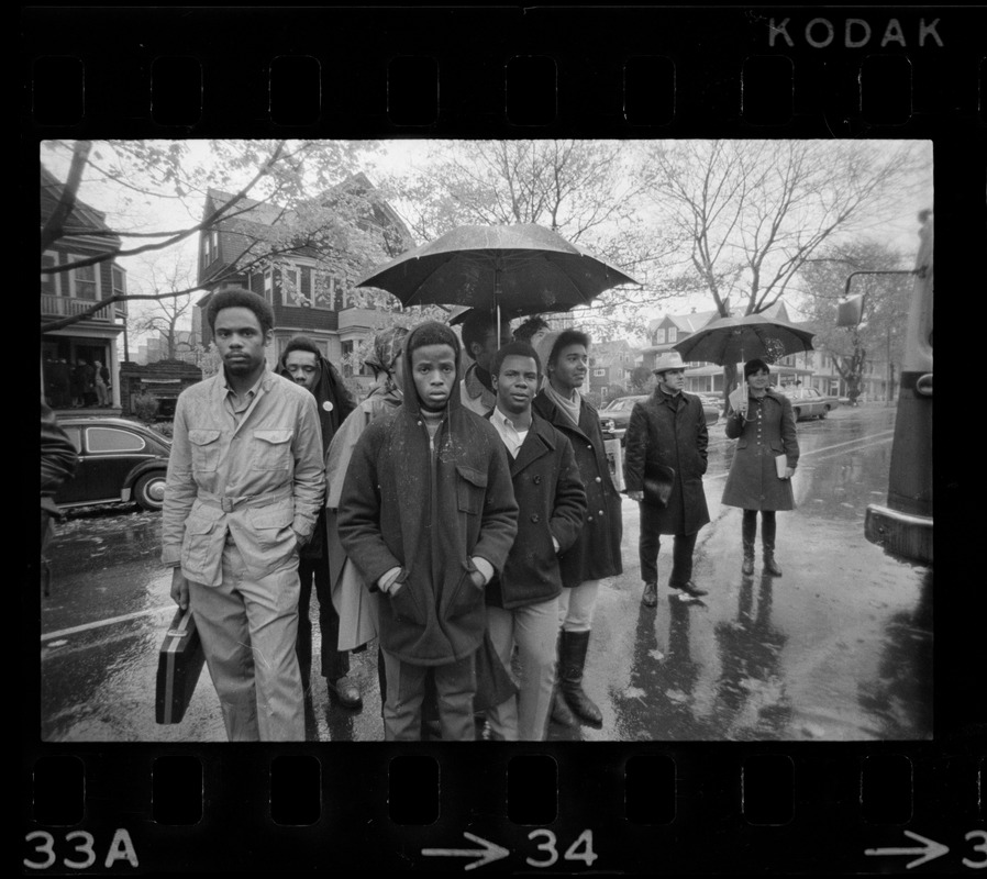 Tufts University students standing in rain on street near dormitory construction site