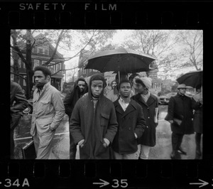 Tufts University students standing in rain on street near dormitory construction site