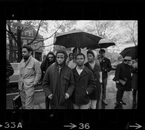 Tufts University students standing in rain on street near dormitory construction site