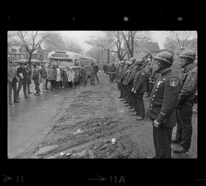 Police standing in front of Tufts University dormitory construction site, the center of student opposition, and facing a group of onlookers