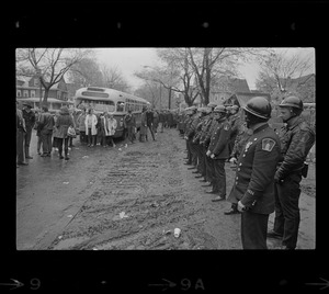 Police standing in front of Tufts University dormitory construction site, the center of student opposition, and facing a group of onlookers