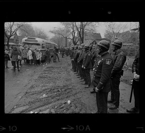 Police standing in front of Tufts University dormitory construction site, the center of student opposition, and facing a group of onlookers