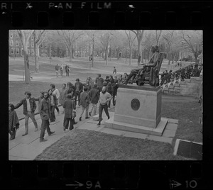 Students marching past John Harvard statue in Harvard Yard in protest