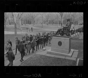 Students marching past John Harvard statue in Harvard Yard in protest