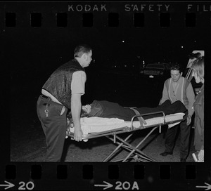 Rescue workers moving a person on a gurney into an ambulance