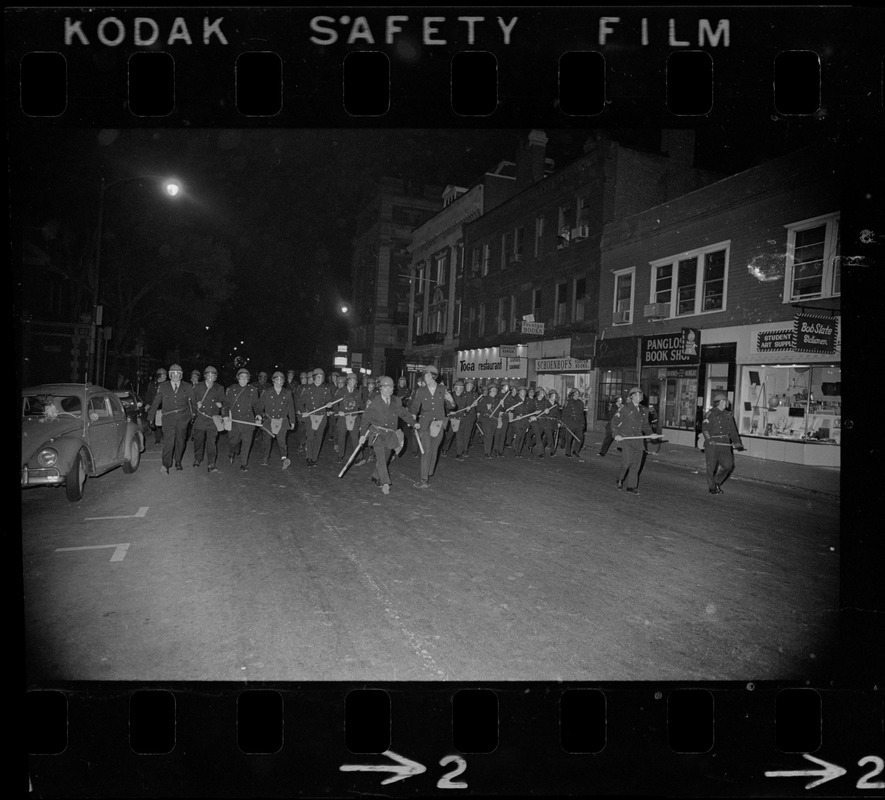 Riot police walking along Massachusetts Avenue in Cambridge