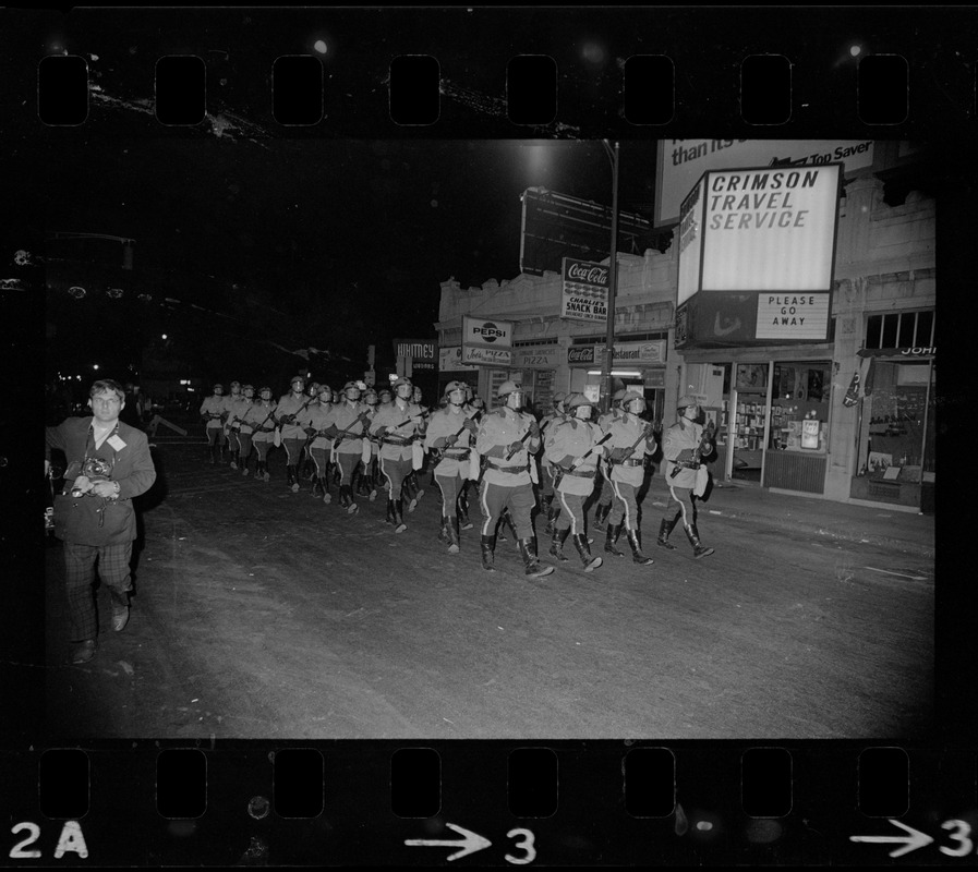 Riot police marching down Massachusetts Avenue in Cambridge