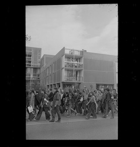 Student protesters marching past an apartment building