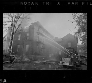 Cambridge fire fighters putting out a fire in a large brick building