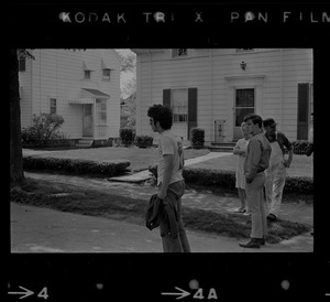 Student protester standing in street in front of a home