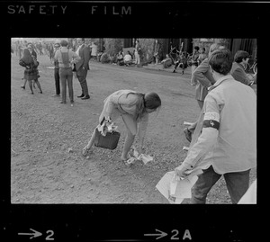 Student protester picking up a flyer at a student rally at Soldiers Field