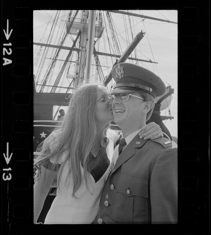 Second lieutenant receiving a kiss aboard the USS Constitution after the Tufts NROTC commissioning ceremony