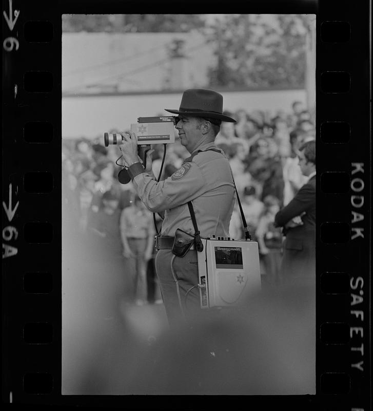 Police officer recording President Ford's visit in Exeter, New Hampshire