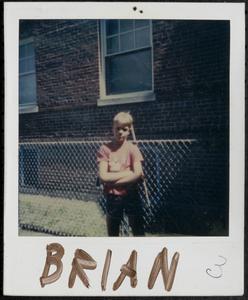 Brian standing in front of fence