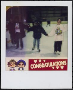 Children holding hands ice skating