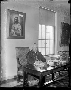 Cardinal O'Connell seated at his desk in Chestnut Hill