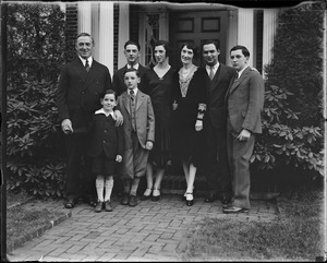 Curley and family in front of house