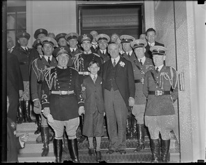 Gov. Curley and son Francis with uniformed men at State House during inaugural