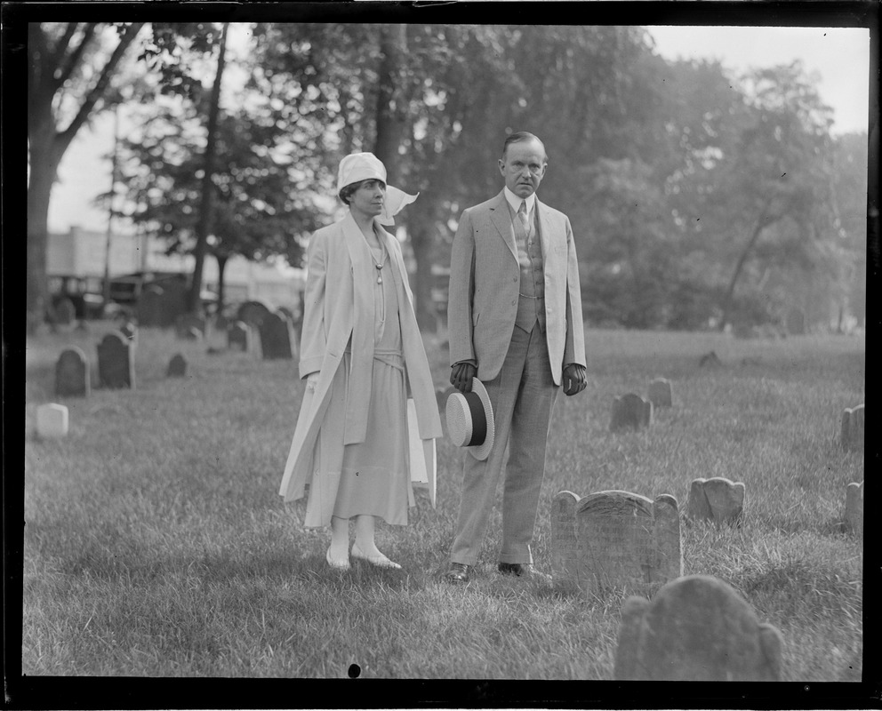 Calvin and Mrs. Coolidge stand next to grave stone