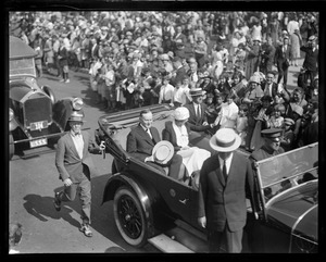 Pres. and Mrs. Coolidge rushing through Plymouth, MA. Cheering crowds bring rare smile to President.