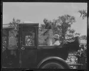 Pres. Harding speaks from auto as wife looks on
