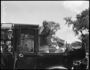 Pres. Harding speaks to crowd while standing in auto.