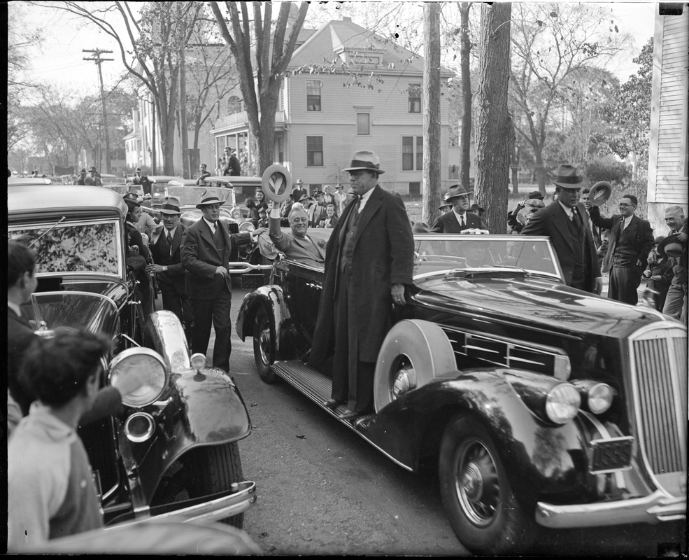 Franklin Delano Roosevelt waving his hat to the crowd from open auto during Boston visit