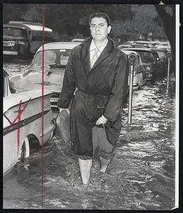 Splashing Along Charles Street between Boston Common and the Public Garden, these cars found the water hubcap-deep and the going mighty slow. Cosimo DeChiara of Waltham, whose car engine stalled in the water, rolled up his trousers and waded out of the flooded Charles street area. He was on his way to a wedding. Scenes like these were common throughout Greater Boston yesterday as cloudbursts dumped up to three inches of water on the area.