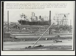 Camille Blows Ships to Shore--Three ships were victims of Hurricane Camille as she blew them to shore at Gulfport Beach last night. Steel sign in foreground was bent by winds. In middle grounds are remains of beach playground.