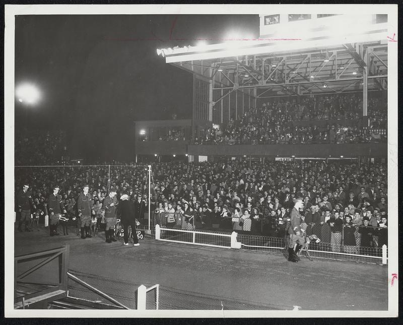 Opening-Night Crowd at Wonderland Park in Revere awaits the magic words, “There goes Swifty.” Picture shows view of grandstand fans and railbirds, with attendants (left) readying greyhounds for action.