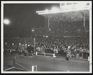 Opening-Night Crowd at Wonderland Park in Revere awaits the magic words, “There goes Swifty.” Picture shows view of grandstand fans and railbirds, with attendants (left) readying greyhounds for action.
