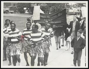 Marchers Attempt to arouse support for starving Biafrans as they proceed along Massachusetts Ave., Cambridge, en route to a memorial service on Boston Common yesterday. Few persons heeded their plea.