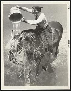 Necessity knows no law. When the heat wave brought Chicago to the boiling point Traffic Policeman Arnold Baer thought it was about time to be doing something for his horse. Try it on your own horse sometime.