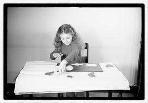 A girl matching fitting shapes in a puzzle
