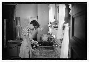 A woman doing laundry at a sink